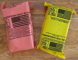 De kleur van de verpakking voor luchtgedropte humanitaire rantsoenen is veranderd van geel in zalm, aangezien geel dezelfde kleur had als luchtgedropte clusterbommen.