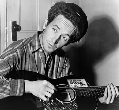 ""Esta Terra É Sua Terra," de Woody Guthrie, uma popular canção folclórica americana entre patriotas, foi originalmente criada como crítica ao Capitalismo e ao governo dos EUA por um organizador comunista do trabalho.